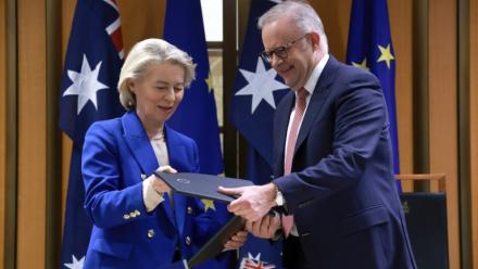 La présidente de la Commission européenne Ursula von der Leyen et le Premier ministre australien Anthony Albanese échangent des copies de l'accord commercial Australie-UE, le 24 mars 2026 à Canberra