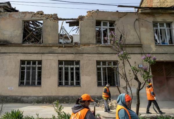 Des employés municipaux nettoient les dégâts causés par une frappe russe sur une école maternelle à Odessa en Ukraine le 30 avril 2026
