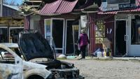Une femme passe devant des magasins endommagés sur le site d’une frappe de missile russe dans la ville de Merefa, dans la région de Kharkiv, le 4 mai 2026
