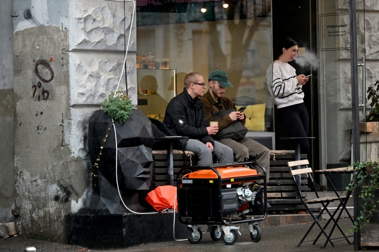 Un générateur en marche devant un café à Kiev durant une coupure de courant causée par des frappes russes sur des installations électriques, le 18 octobre 2026