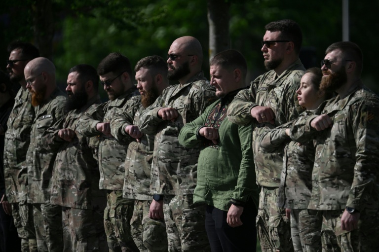 Des militaires ukrainiens assistent à la cérémonie de réinhumation du leader nationaliste controversé Andriï Melnyk, décédé en 1964 au cimetière national militaire commémoratif près de Kiev, le 25 mai 2026