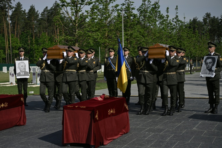 Des soldats ukrainiens portent les cercueils du leader nationaliste controversé Andriï Melnyk et de son épouse Sofia, lors d'une cérémonie de réinhumation au cimetière national militaire commémoratif près de Kiev, le 25 mai 2026