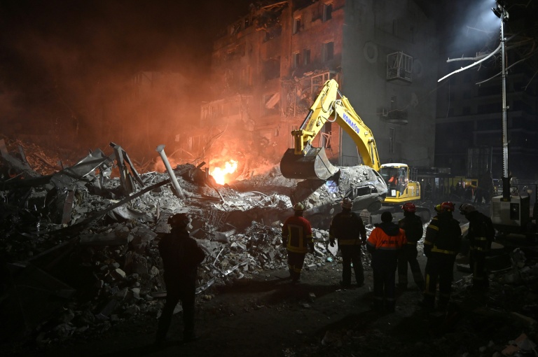 Des pompiers s'affairent dans les ruines d'un immeuble détruit par un raid aérien russe à Kharkiv, en Ukraine, le 2 janvier 2026 