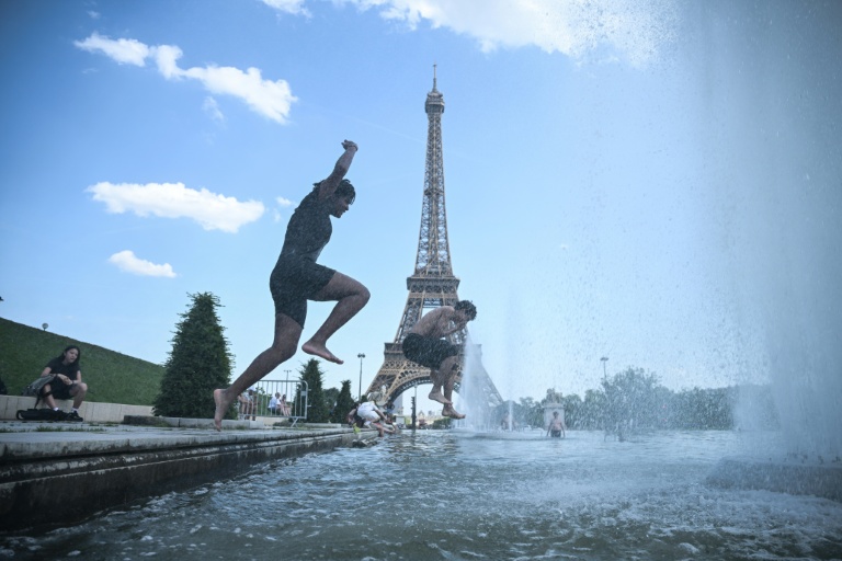 Des personnes sautent dans la fontaine du Trocadero, près de la tour Eiffel, à Paris le 22 juin 2026