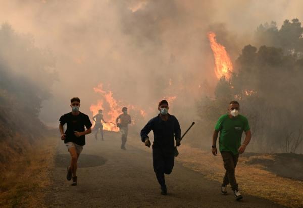 Des personnes fuient les flammes à Larouco, dans le nord-ouest de l'Espagne, le 13 août 2025
