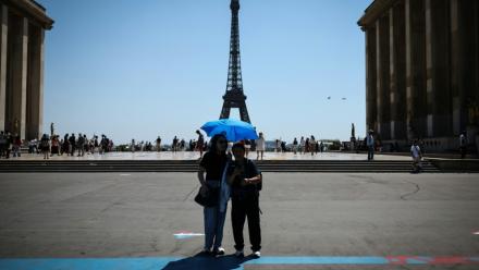 Des touristes se protègent du soleil au Trocadéro à Paris, le 18 juin 2026