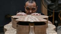 Cette photo prise le 27 juillet 2026 montre un ouvrier fabriquant une guitare dans un atelier de lutherie à Zheng'an, dans la province du Guizhou, dans le sud-ouest de la Chine.