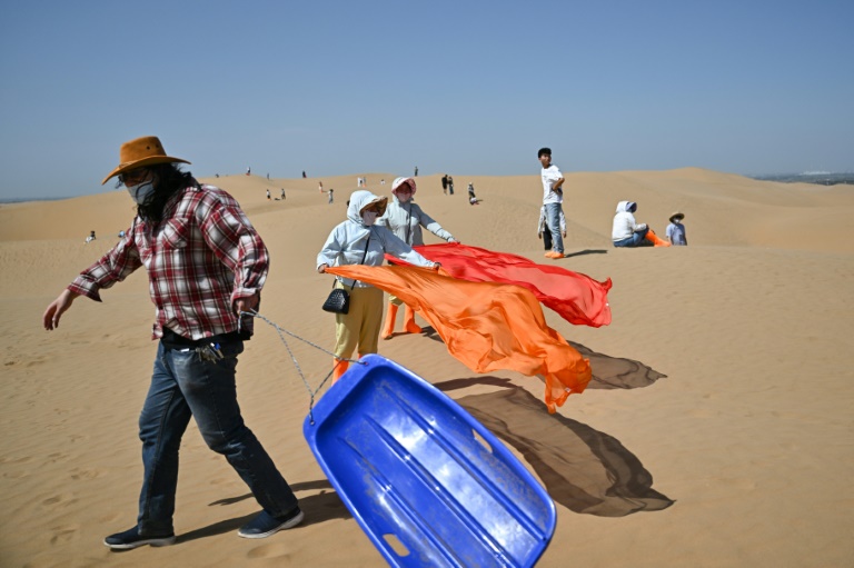Des touristes dans le désert de Kubuqi, près d'Ordos, dans le nord de la Chine, le 11 août 2025