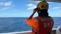 Cette photo fournie le 29 décembre 2025 par les garde-côtes taïwanais montre un agent observant un navire chinois, naviguant à 23 milles marins au nord-ouest de l'îlot Pengjia, au nord de Taïwan