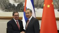 Le ministre chinois des Affaires étrangères Wang Yi (d) et le ministre cubain des Affaires étrangères Bruno Rodriguez Parrilla se serrent la main avant leur rencontre à la maison d'hôtes d'Etat Diaoyutai à Pékin, le 12 mai 2025