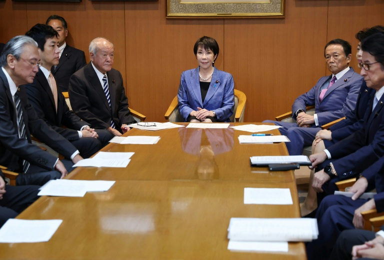 La présidente du Parti libéral démocrate (PLD) au pouvoir au Japon, Sanae Takaichi (au centre), marche avant de signer un accord à la Diète à Tokyo, le 20 octobre 2025