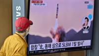Passant regardant un tir de missile nord-coréen sur un écran de la gare de Séoul, le 7 mai 2022