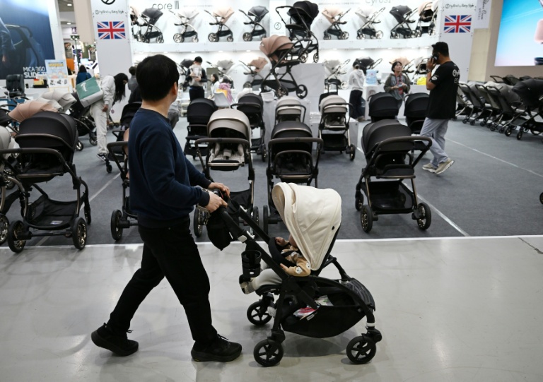 Un homme avec sa poussette dans une allée d'un salon de l'enfant, le 30 avril 2026 à Séoul 