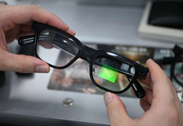 Un optométriste tenant une paire de lunettes connectées dans un magasin d'optique de Séoul, le 30 octobre 2026
