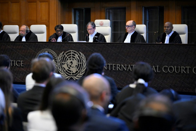 Le président de la Cour de justice internationale Yuji Iwasawa (C) présente la premier avis consultatif de l'institution sur les obligations légales des pays face aux changements climatiques, le 25 juillet 2025 à La Haye