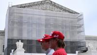 Deux hommes portant des casquettes "Make America Great Again" (MAGA, Rendre sa grandeur à l'Amérique), passent devant la Cour suprême des Etats-Unis, à Washington, le 27 juin 2025
