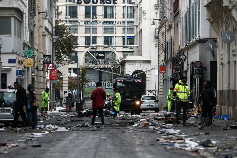 Des employés municipaux nettoient une rue jonchée de débris au lendemain d'une manifestation contre la vie chère, le 18 octobre 2026 à Marseille