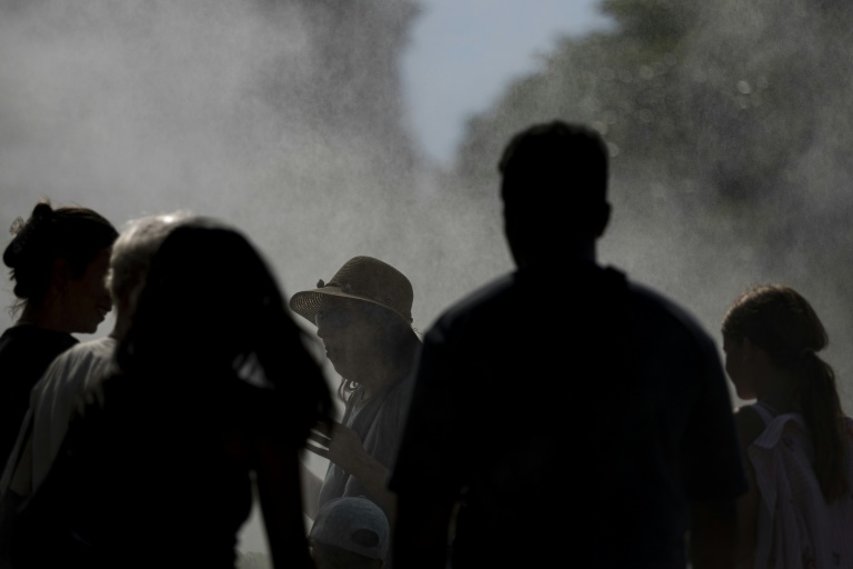 Des personnes sous un système de rafraichissement pendant la canicule à Strasbourg, le 20 juin 2026