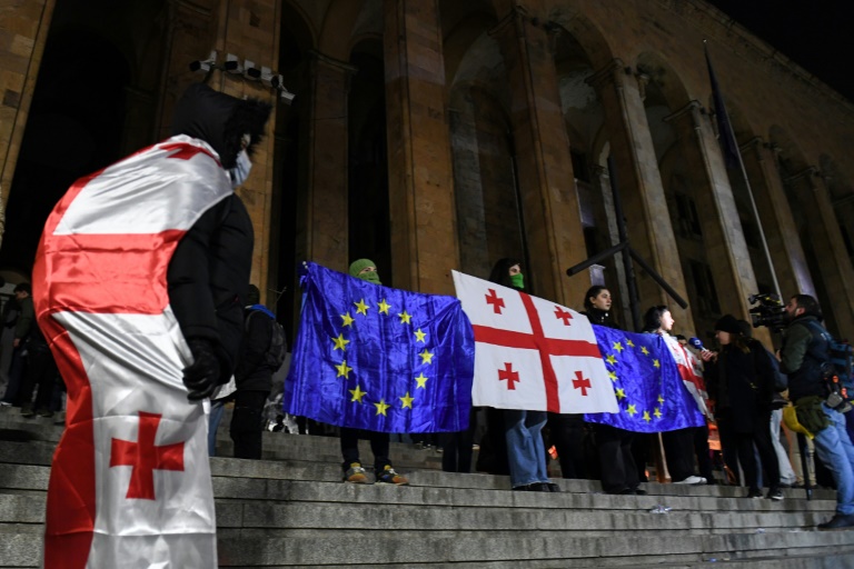 Des manifestants brandissent les drapeaux de la Géorgie et de l'Union européenne lors de la vague de contestation qui a suivi les élections législatives de 2024, le 5 décembre 2024 à Tbilissi
