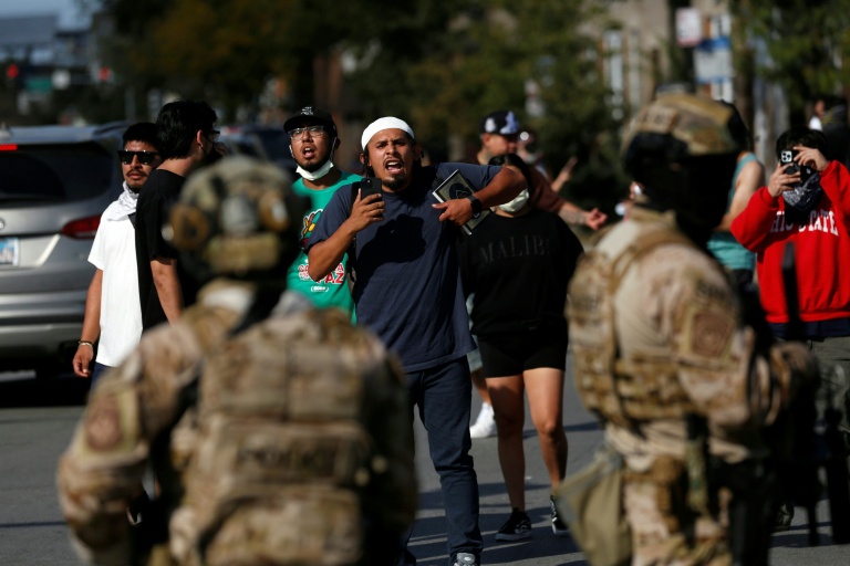 Un homme filme les forces de l'ordre à Chicago, le 4 octobre 2025