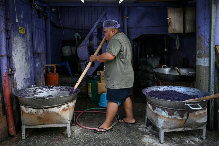 Un employé prépare une pâte d'igname violette (ube) dans une échoppe à Manille, le 1er octobre 2026 aux Philippines