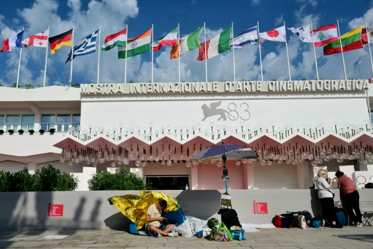 Des festivaliers campent sur le Lido devant le tapis rouge de la Mostra de Venise, en Italie, le 1er septembre 2026