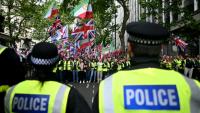 Des policiers face à des partisans de Tommy Robinson, militant d'extrême droite britannique, rassemblés pour une marche organisée par Unite The Kingdom, le 16 mai 2026 à Londres