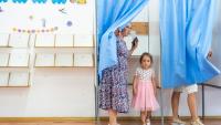 Une femme vote avec sa fille pour la présidentielle roumaine, le 4 mai 2025 à Ciocanesti