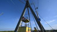 Des techniciens réparent une ligne électrique de trolleybus à proximité des dégâts constatés sur un pilier du pont, à la suite d’une attaque de drone contre le pont du Nord à Kiev, le 3 octobre 2026