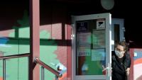 Une employée de la sécurité porte un masque de protection à l'entrée d'un hôpital spécialisé dans les maladies infectieuses à Chelekhov, dans la région d'Irkoutsk, le 7 octobre 2026 en Russie