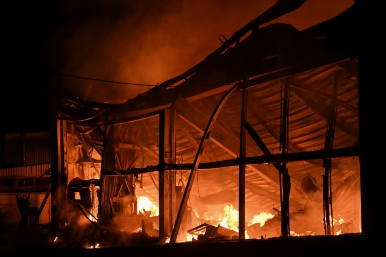 Des pompiers luttent contre un incendie sur le site d'une attaque de drone russe à Kharkiv, le 23 septembre 2025 en Ukraine