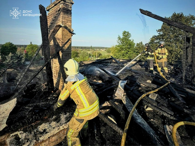 Image fournie par les services d'urgence ukrainiens de pompiers ukrainiens qui éteignent un incendie après une frappe de drone russe à Kiev le 12 mai 2026