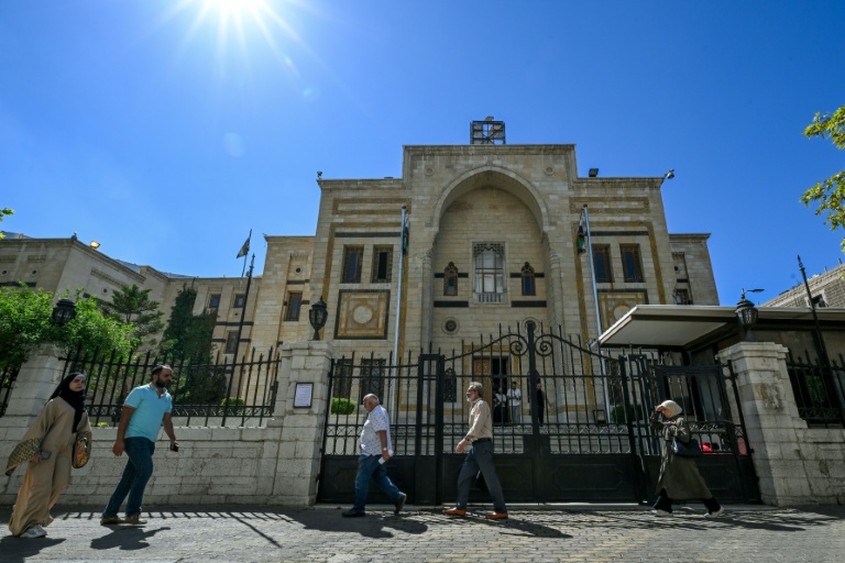 Des personnes passent devant le bâtiment du Parlement à Damas, le 1er octobre 2025