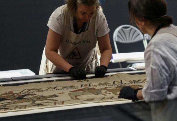 Des employées préparent la tapisserie de Bayeux présentée aux médias au British Museum, le 17 juillet 2026 à Londres