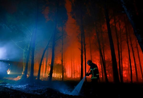 Un pompier lutte contre un feu de forêr à Luglon, dans les Landes, le 14 août 2026