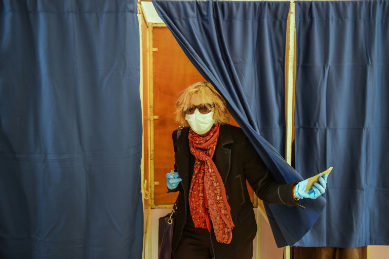 Une femme portant un masque sort d'un isoloir lors du premier tour des élections municipales, le 15 mars 2020 à Bordeaux