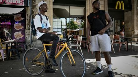 Deux livreurs à vélo se reposent pendant une vague de chaleur estivale près des restaurants en attendant des commandes, à Bordeaux, le 7 juillet 2026