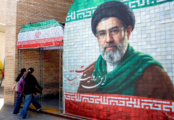 Des Iraniennes passent devant un portrait du nouveau guide suprême iranien, le 6 mai 2026 à Téhéran