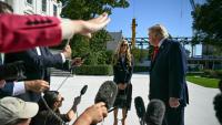Le président américain Donald Trump se tourne vers la nouvelle porte-parole de la Maison Blanche, Kate Zacharia, devant la presse à Washington le 13 octobre 2026