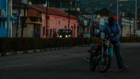 Un homme déplace une moto lors d'une panne de courant, le 14 mai 2026 à Santiago de Cuba