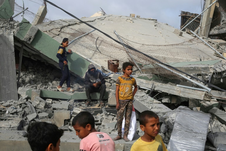 Des Palestiniens observent les décombres de la mosquée Al-Hassanat après un bombardement israélien, dans le camp de réfugiés de Nousseirat, au centre de la bande de Gaza, le 12 mai 2025