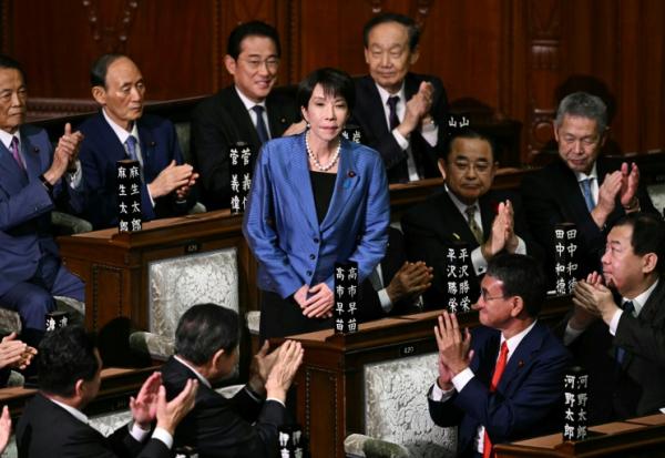 La présidente du Parti libéral démocrate (PLD) Sanae Takaichi (c) est applaudie après avoir été nommée nouvelle Première ministre du Japon lors d'une session extraordinaire de la chambre basse du Parlement à Tokyo, le 21 octobre 2025