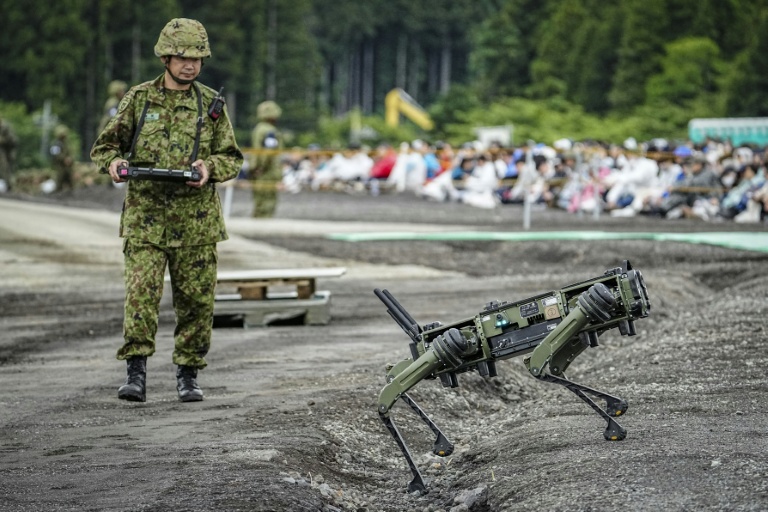 Un soldat de la Force terrestre d'autodéfense japonaise (JGSDF) manoeuvre un véhicule terrestre quadrupède sans pilote lors d'un exercice de tir réel dans la zone d'East Fuji, à Gotemba, le 7 juin 2026 au Japon
