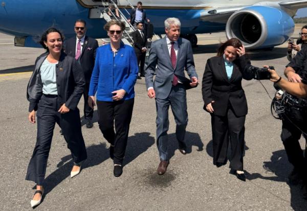Photo diffusée par l'ambassade des Etats-Unis au Venezuela du ministre américain de l'Energie, Chris Wright (2e à droite), aux côtés de la cheffe de la mission diplomatique américaine au Venezuela, Laura Dogu (2e à gauche), à son arrivée à l'aéroport international de Maiquetia, le 11 février 2026