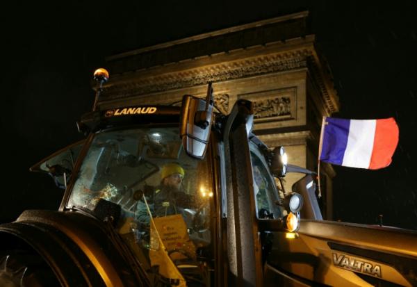 Un tracteur arborant le drapeau français est garé devant l'Arc de Triomphe lors d'une manifestation d'agriculteurs, le 8 janvier 2026 à Paris