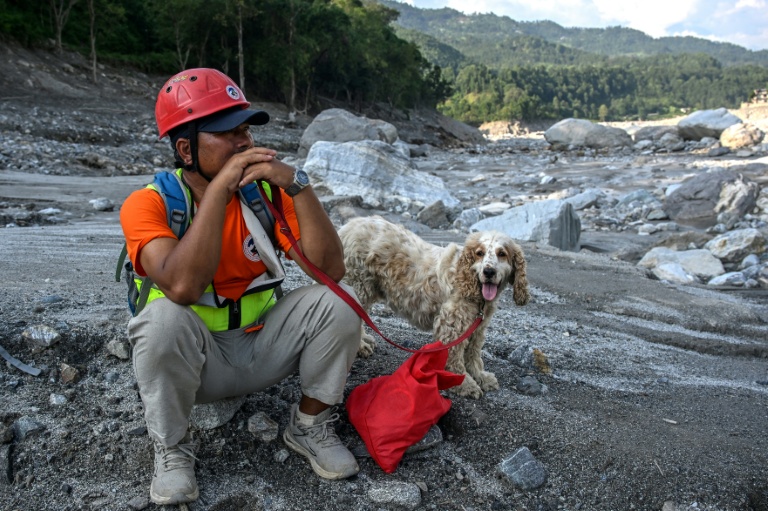 Un secouriste avec un chien de sauvetage sur les rives de la rivière Trishuli dans le district de Nuwakot, au Népal, où ils recherchent des disparus le 30 septembre 2026