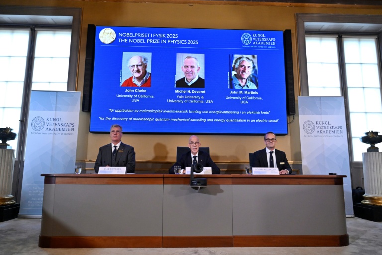 Un écran affiche les portraits des lauréats du prix Nobel de Physique 2025 (g-d) Le Britannique John Clarke, le Français Michel H Devoret et l'Américain John M Martinis lors d'une conférence de presse à l'Académie royale des sciences de Suède, le 7 octobre 2025 à Stockholm