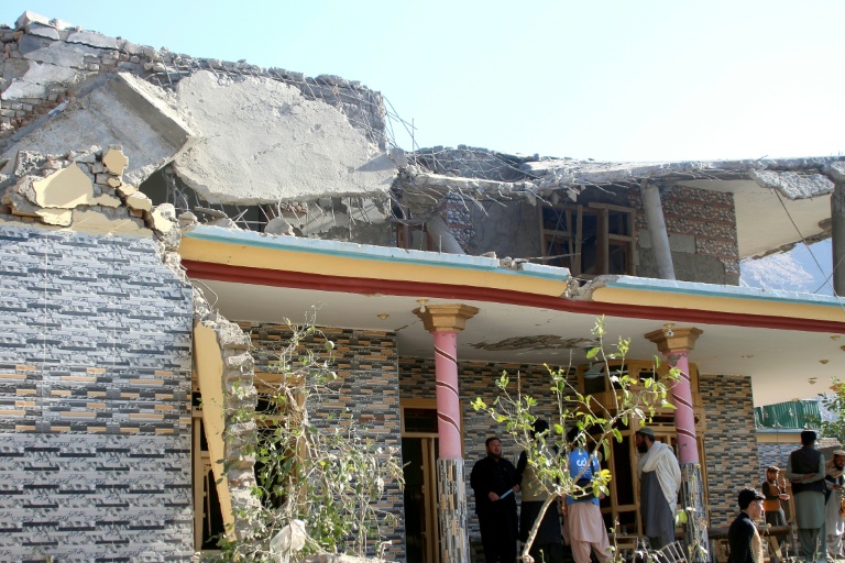 Des Afghans se rassemblent devant une maison endommagée par une frappe pakistanaise à Asadabad dans l'est de l'Afghanistan le 25 novembre 2025