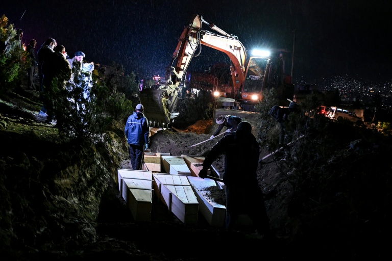 Des personnes déposent dans une fosse commune les cercueils de victimes tuées lors d'une frappe aérienne pakistanaise contre un hôpital pour toxicomanes, le 18  mars 2018 à Kaboul