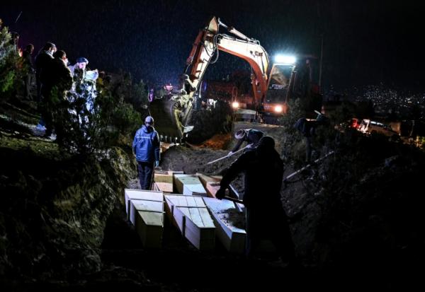 Des personnes déposent dans une fosse commune les cercueils de victimes tuées lors d'une frappe aérienne pakistanaise contre un hôpital pour toxicomanes, le 18  mars 2018 à Kaboul